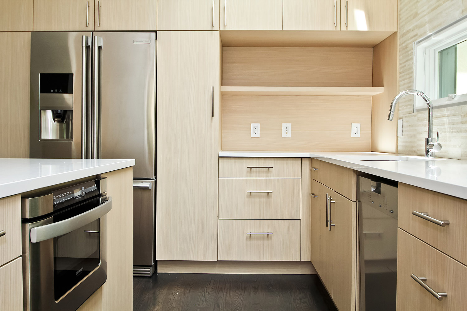 Scandinavian style sand-colored cabinets and modern appliances in a newly renovated kitchen