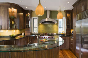 Eclectic green kitchen with glass countertops and dark solid wood cabinets